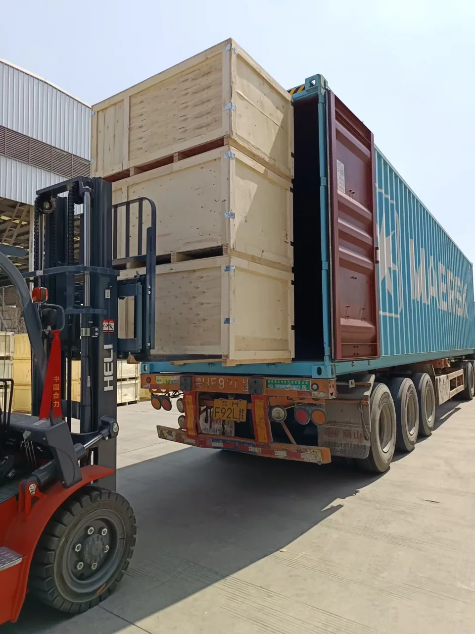 Crated machinery being loaded into a shipping container
