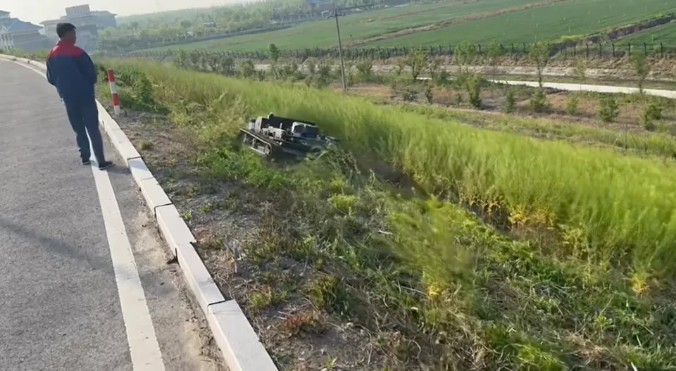 Operator controlling a mower beside a road