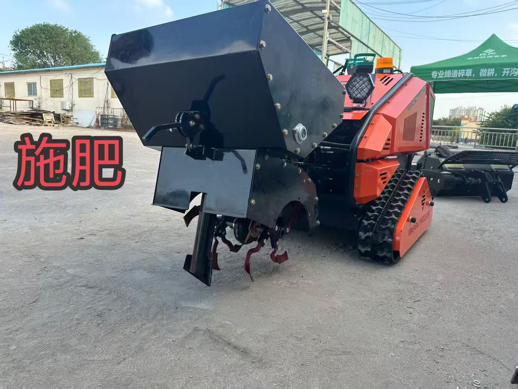 Orange multi-purpose tracked machine shown with a fertilizer attachment
